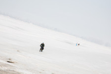 Sasha riding his bike over the frozen Volga to clean roofs of snow.