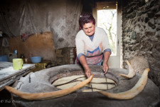 A Georgian woman making bread on the side of a road.