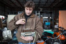 Mikhail fixing a radio for a GAZ 21 Volga car.