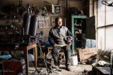 Dmitry in his garage holding one of his sculptures.