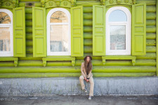 Lena sitting in front of one of Ulan-Ude's many wooden homes.