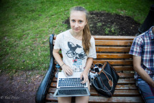 Anna sitting in the park learning to build a website.